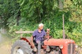 An Indian senior farmer plowing the field with sitting on a tractor Royalty Free Stock Photo